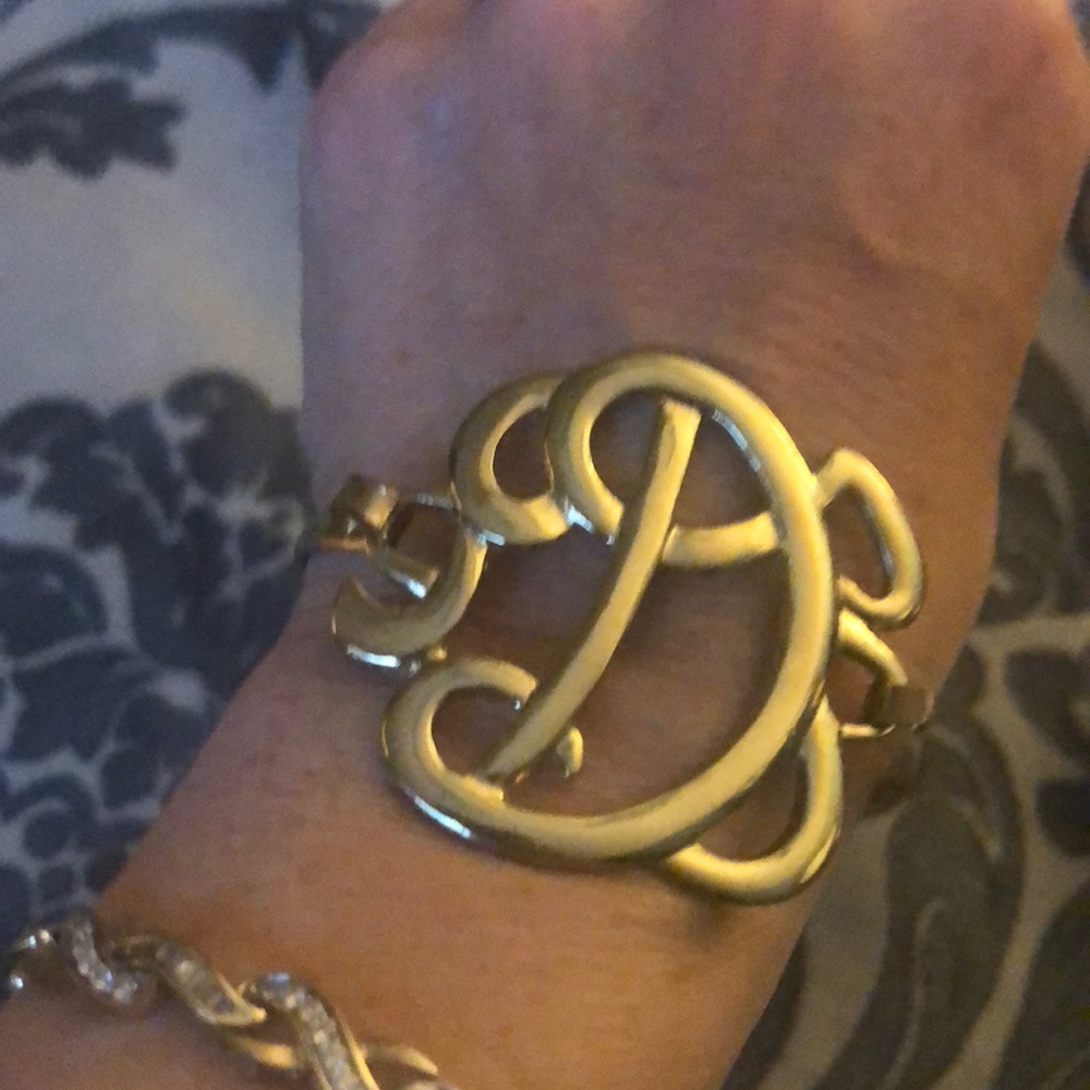 Gold tone Large script D clasp bracelet.
